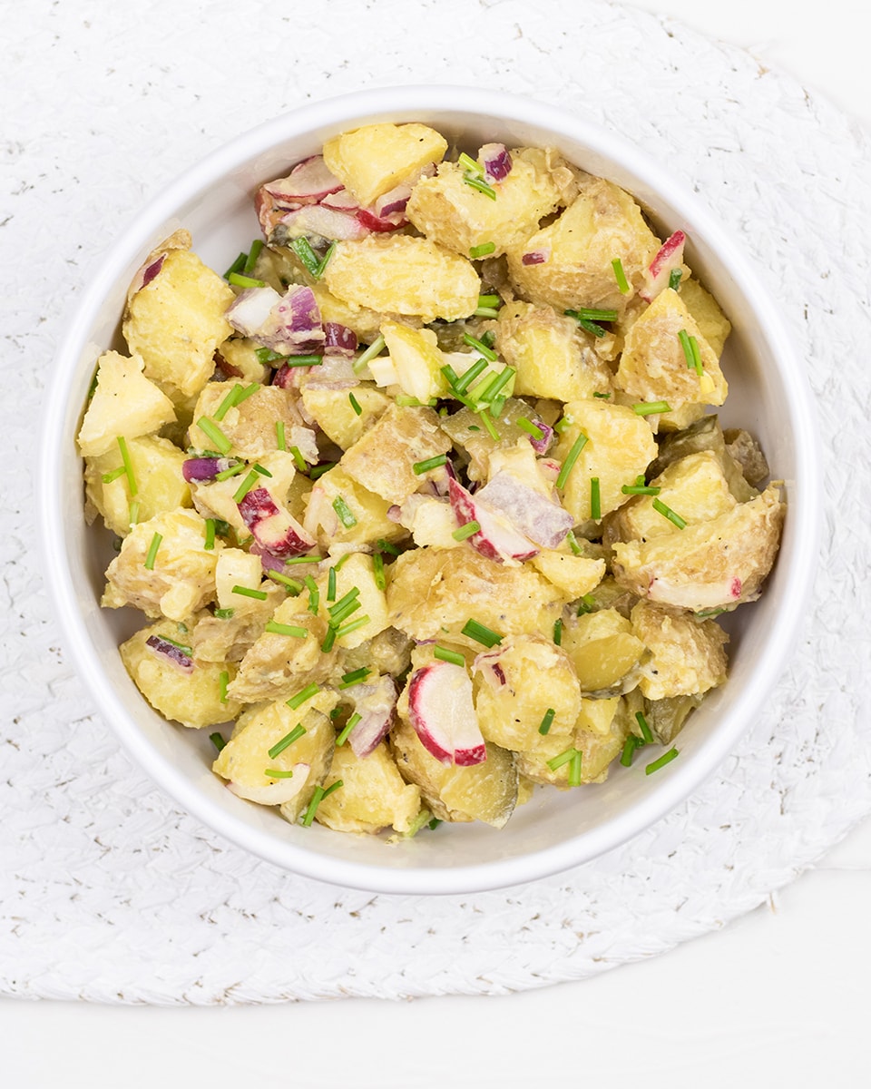 Vegetarian potato salad with apple, radish, pickles and onion